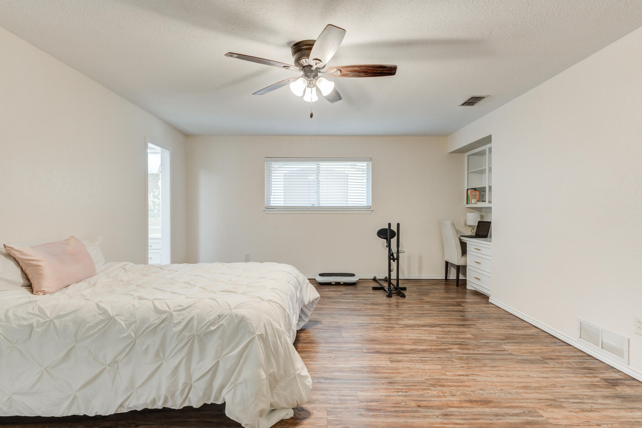 5703 80th Street Lubbock, TX 79424 - Photo 28 of 45 a bedroom with a bed and a chandelier