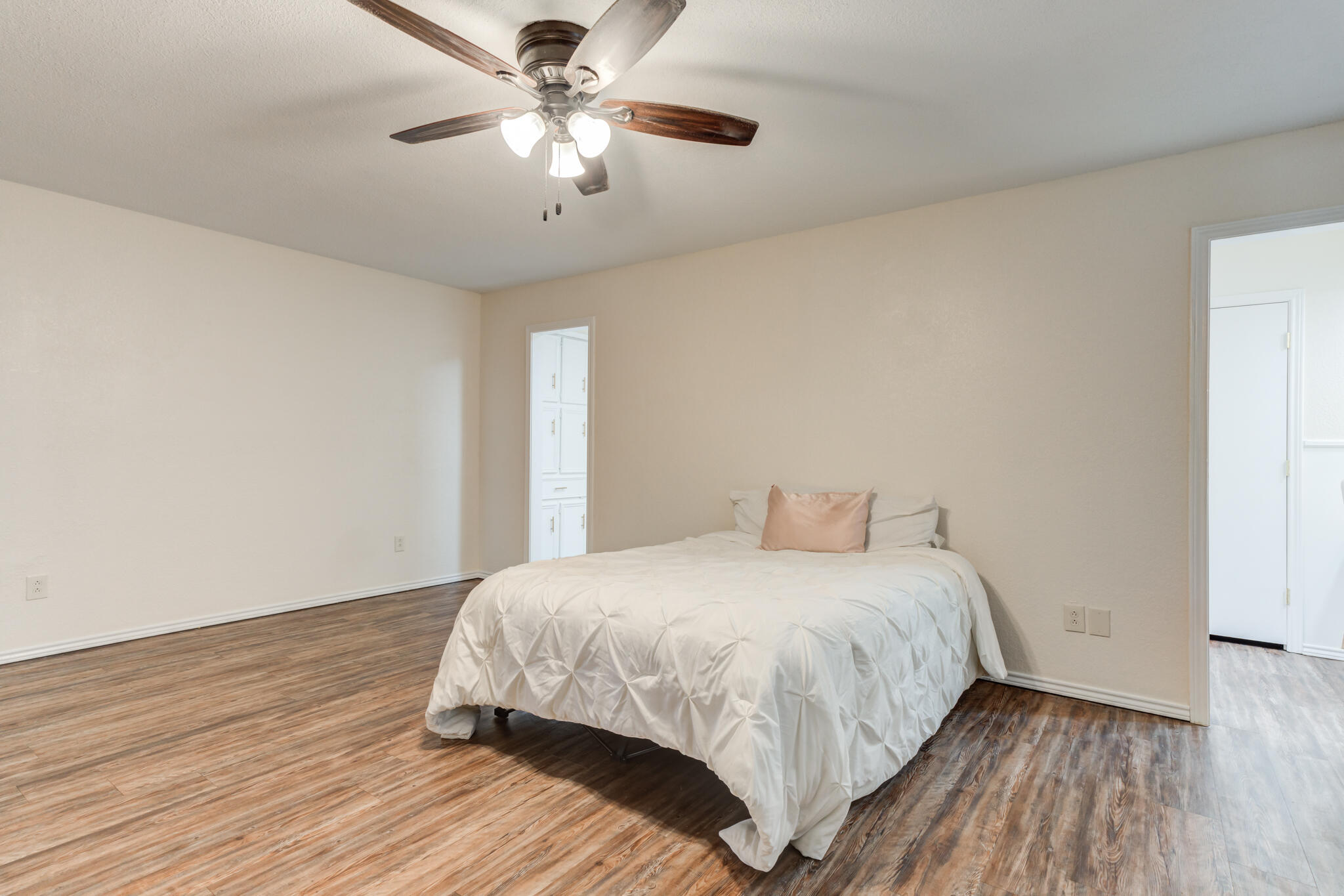 5703 80th Street Lubbock, TX 79424 - Photo 30 of 45 a bedroom with a large bed chandelier and a window