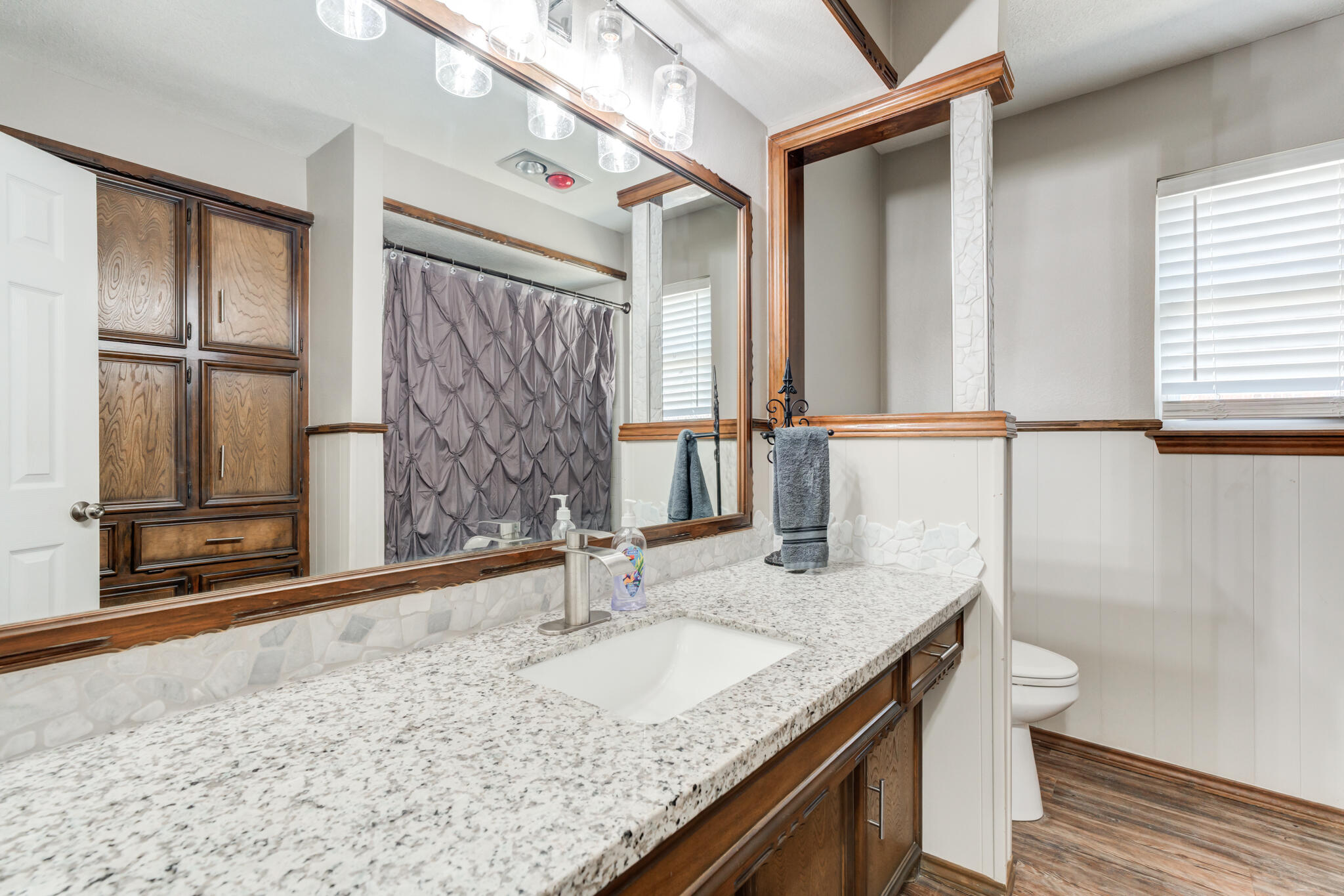 5703 80th Street Lubbock, TX 79424 - Photo 8 of 45 a bathroom with a granite countertop sink and a mirror