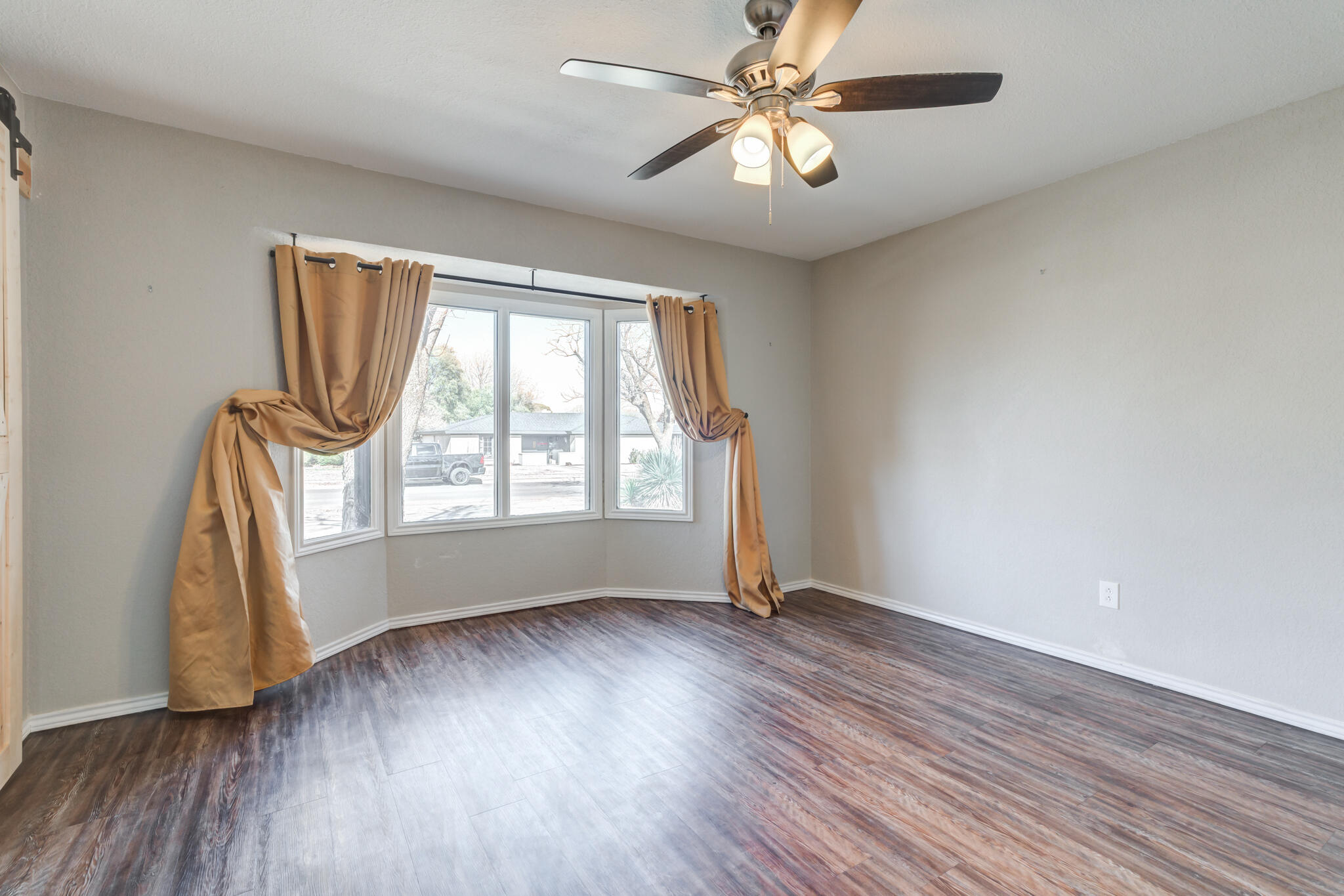 5703 80th Street Lubbock, TX 79424 - Photo 9 of 45 an empty room with wooden floor fan and windows