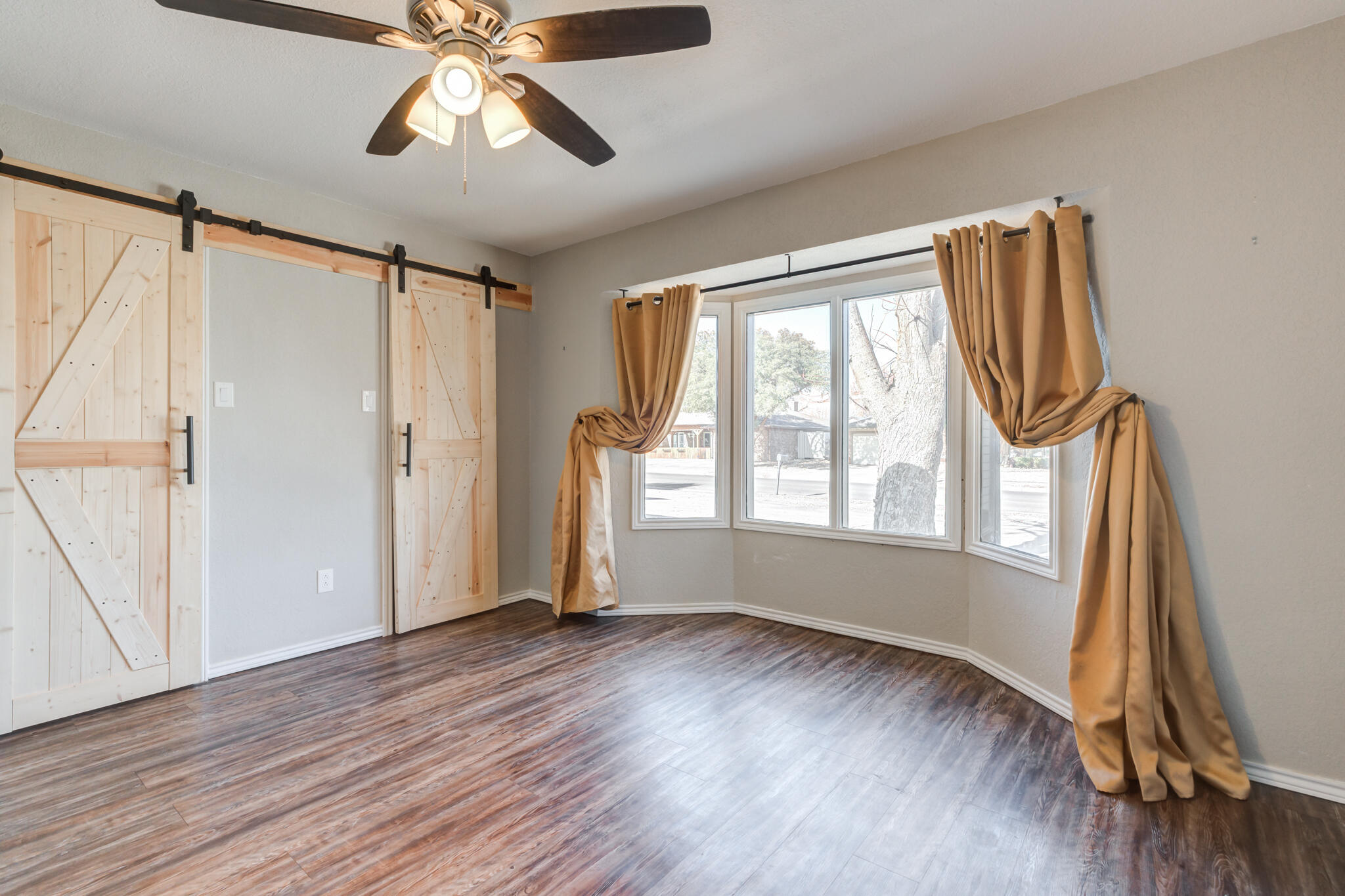 5703 80th Street Lubbock, TX 79424 - Photo 10 of 45 a view of empty room with wooden floor and fan