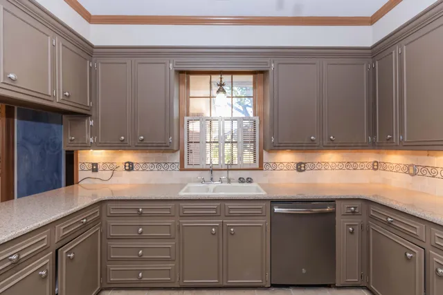 a view of a livingroom with a chandelier fan and windows