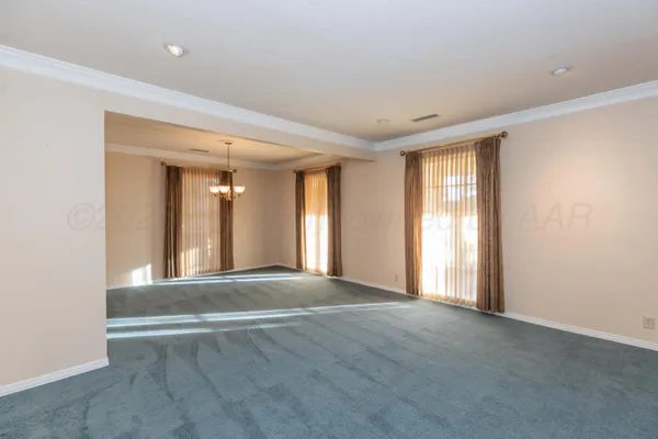 a view of an empty room with wooden floor and stairs