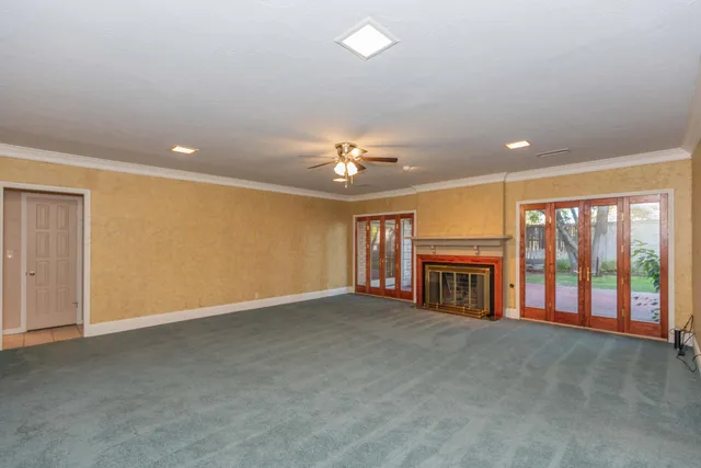 a view of an empty room with a fireplace and a large window