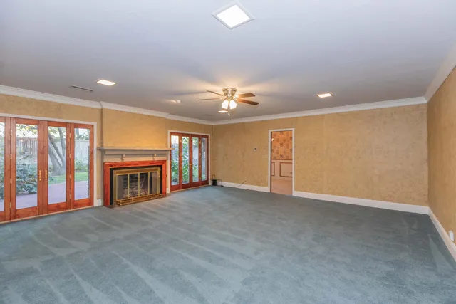 a view of an empty room with a fireplace and a window