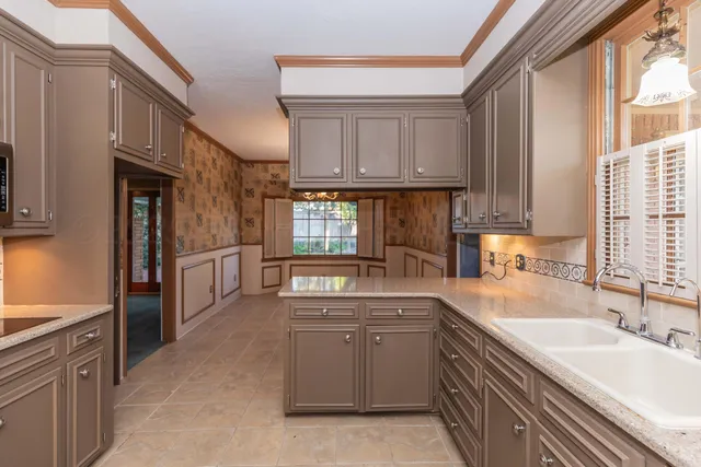 a kitchen with stainless steel appliances granite countertop a stove a sink and a microwave