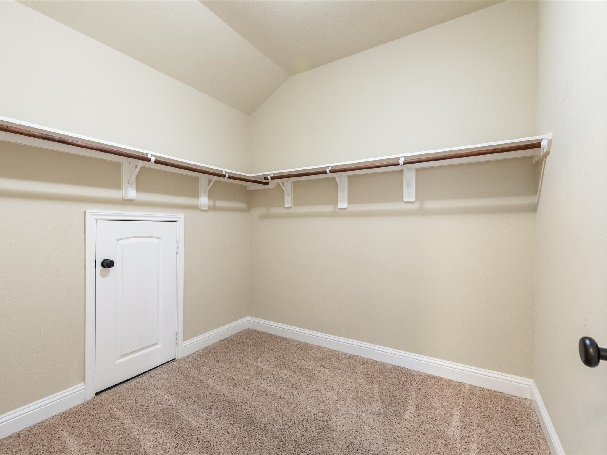 3907 Randle Ridge Court Fulshear, TX 77441 - Photo 34 of 46 This spacious walk-in closet with attic access has ample hanging space provided by perimeter shelves. A small door offers additional storage or access to utilities.