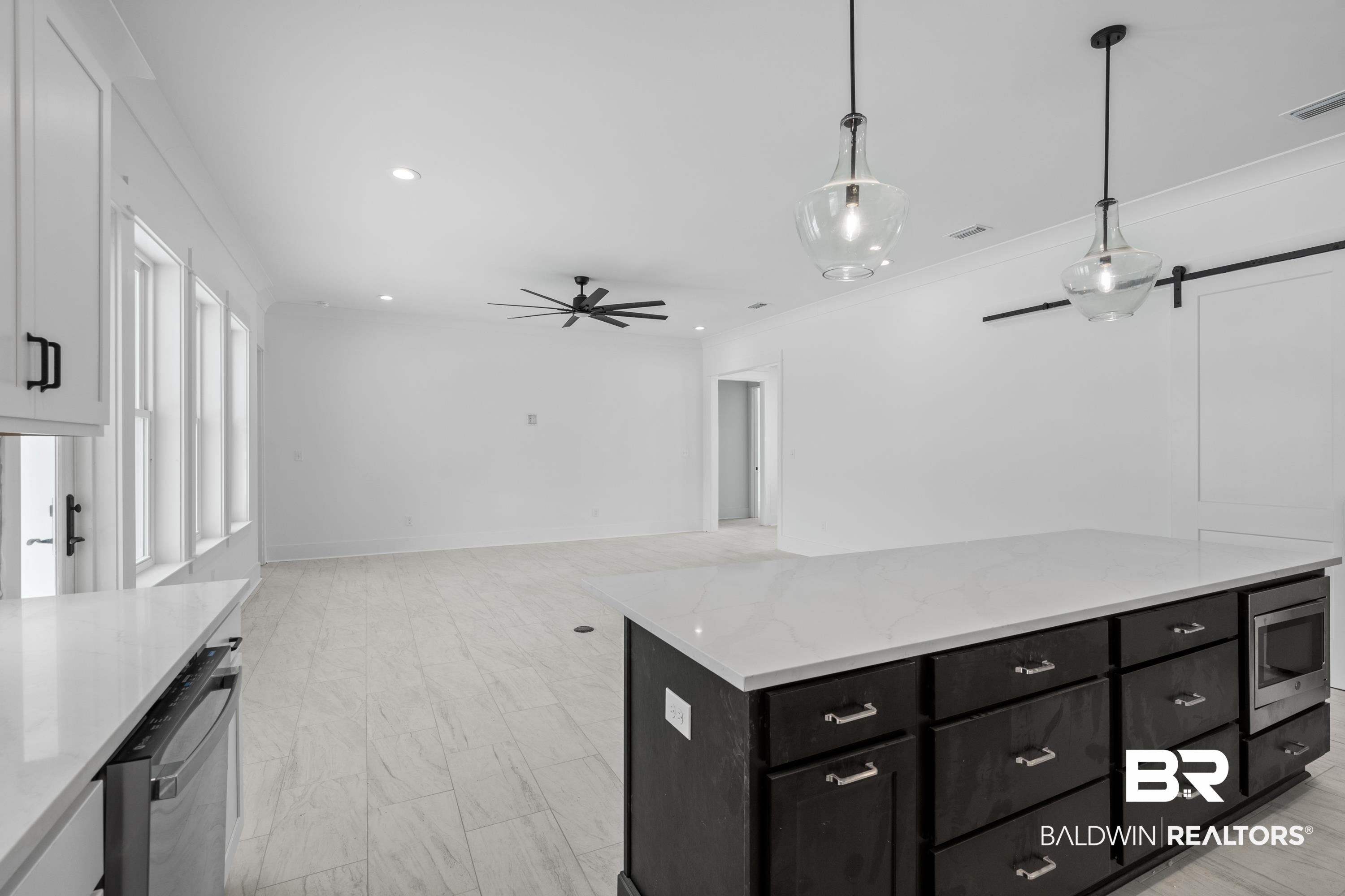 30650 Ono N Loop West Orange Beach, AL 36561 - Photo 12 of 38 Kitchen featuring dark cabinets, appliances with stainless steel finishes, white cabinetry, ceiling fan, and pendant lighting