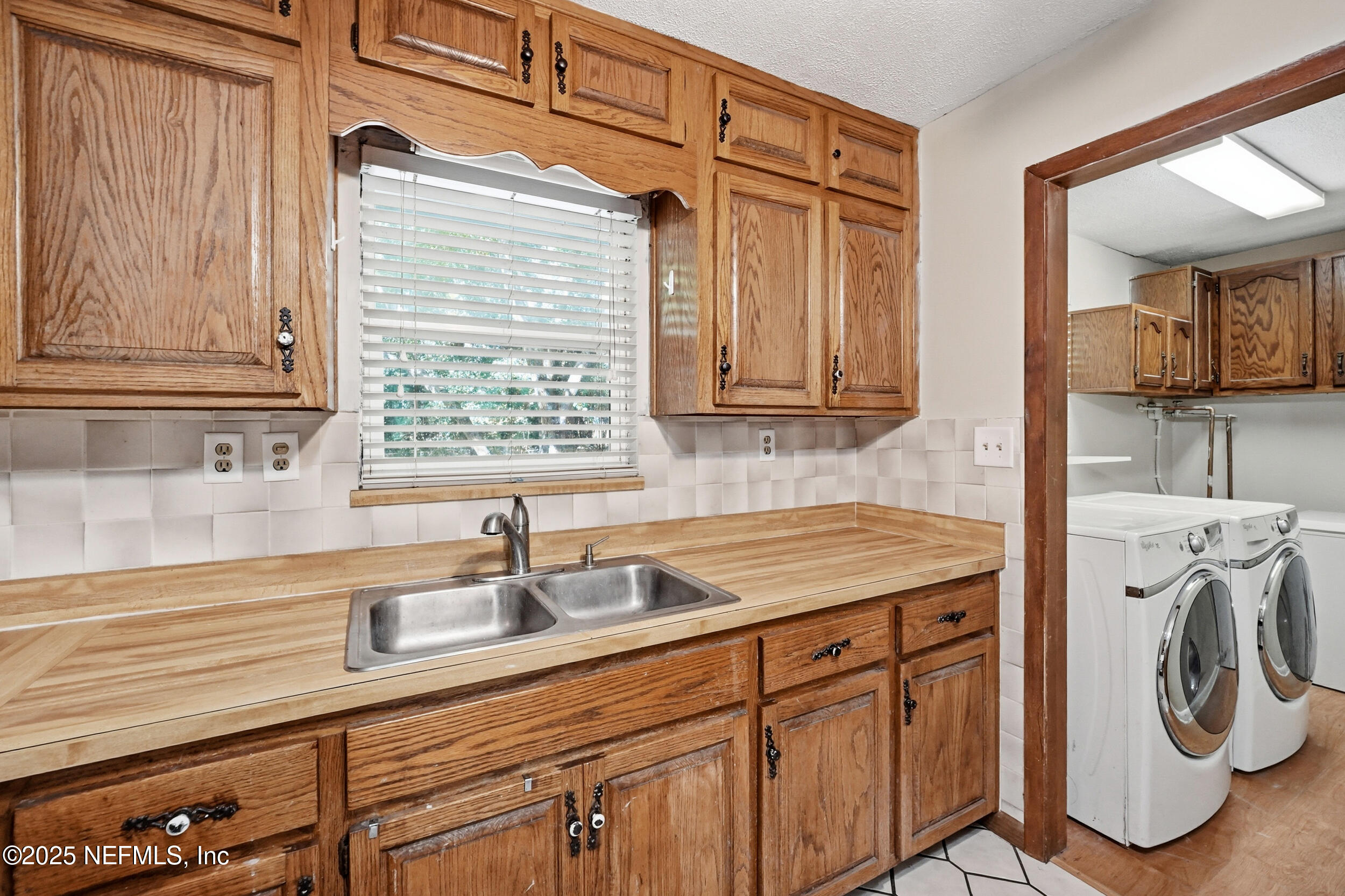 11948 Aaron Road Jacksonville, FL 32218 - Photo 17 of 33 a kitchen with stainless steel appliances white cabinets sink and window