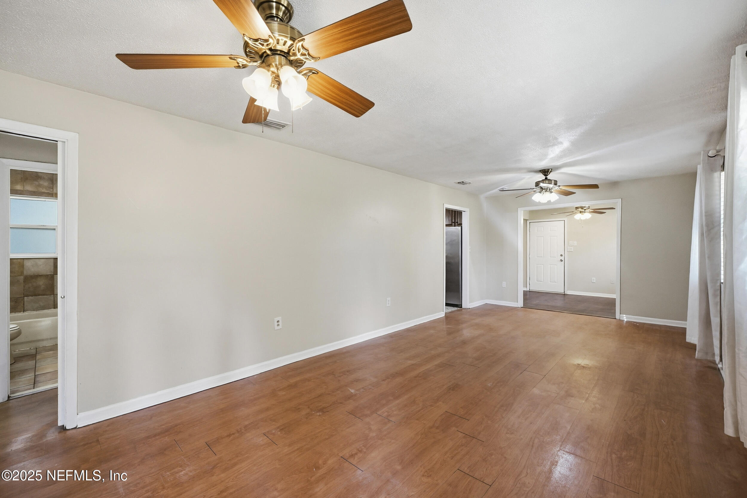 11948 Aaron Road Jacksonville, FL 32218 - Photo 9 of 33 an empty room with chandelier fan and windows