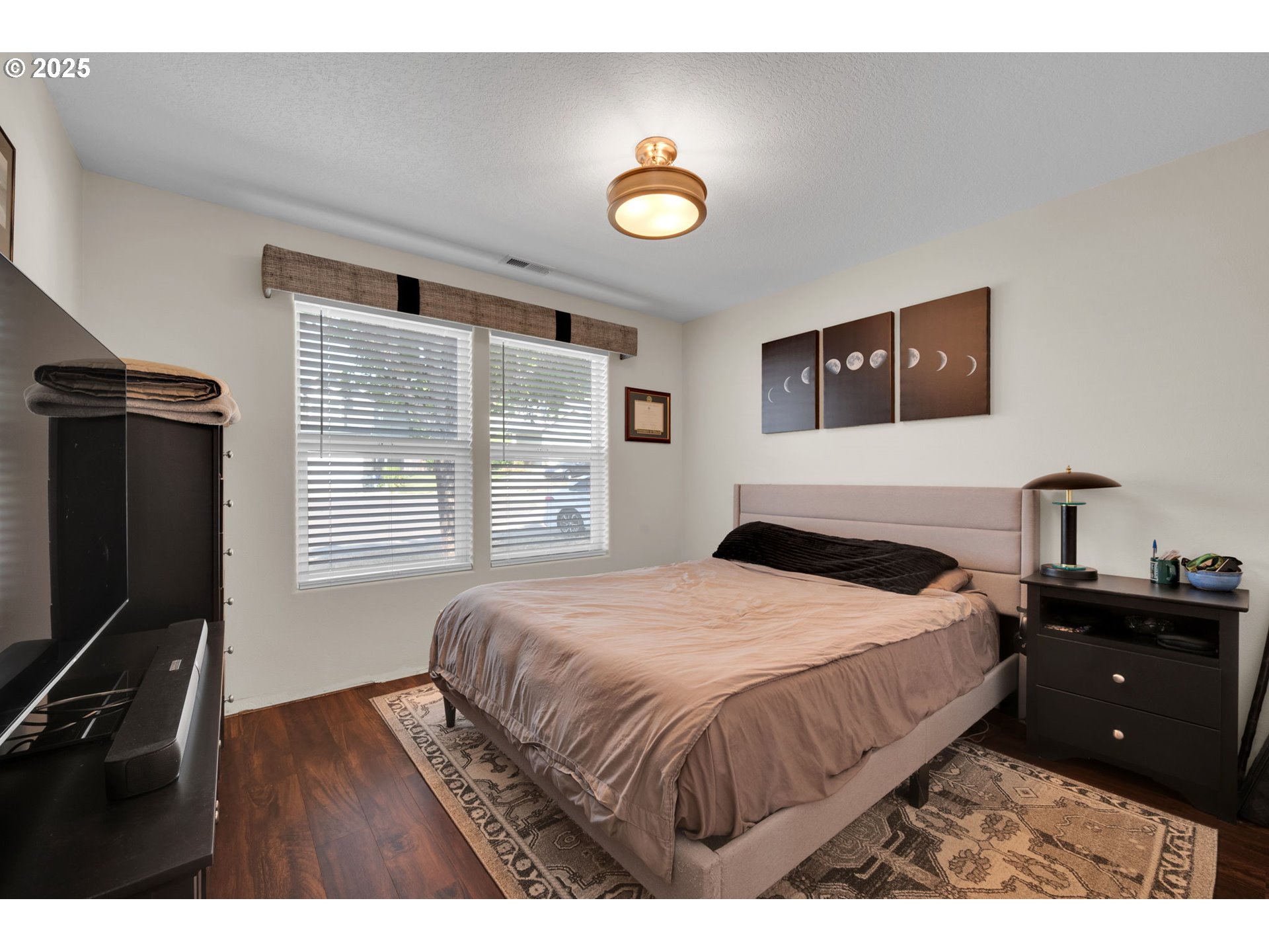 6057 Pebble Court Springfield, OR 97478 - Photo 18 of 42 a bedroom with a bed and a flat tv screen on dresser