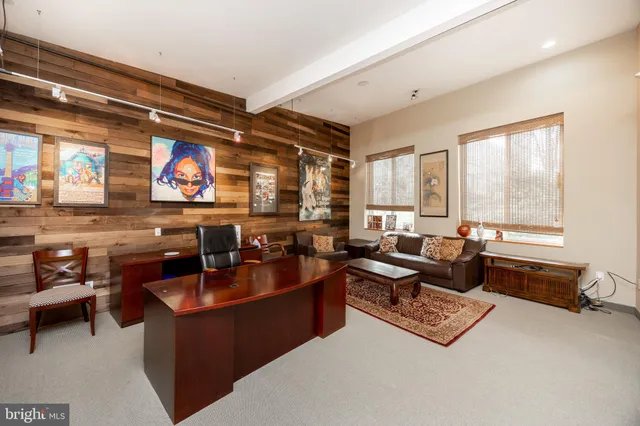 a view of a livingroom with workspace and a window