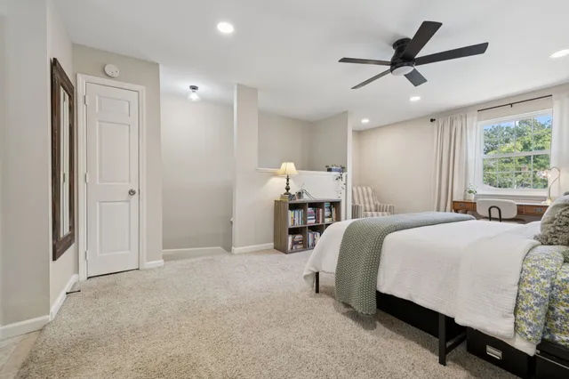 a spacious bedroom with a bed and ceiling fan