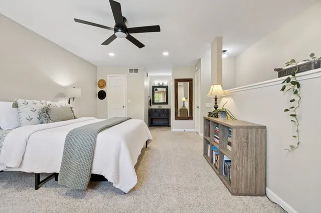 a spacious bedroom with a bed and a chandelier