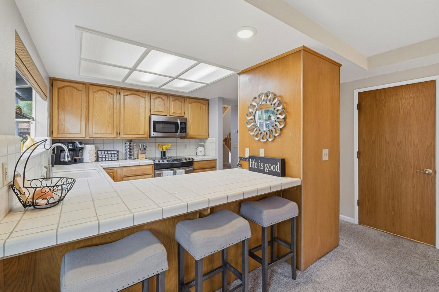 303 Dry Creek Road Aptos, CA 95003 - Photo 14 of 41 a kitchen with a refrigerator a stove a sink dishwasher a dining table and chairs with wooden floor