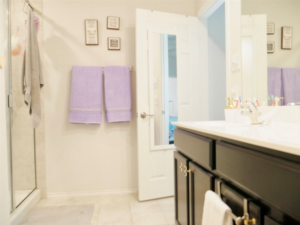 524 Taggart Trail Jarrell, TX 76537 - Photo 12 of 18 a bathroom with a sink a mirror and a shower