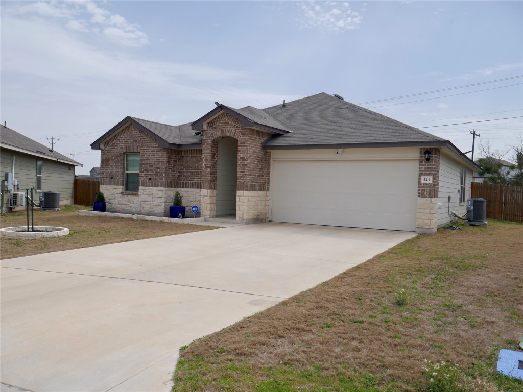 524 Taggart Trail Jarrell, TX 76537 - Photo 2 of 18 a front view of a house with a yard and garage