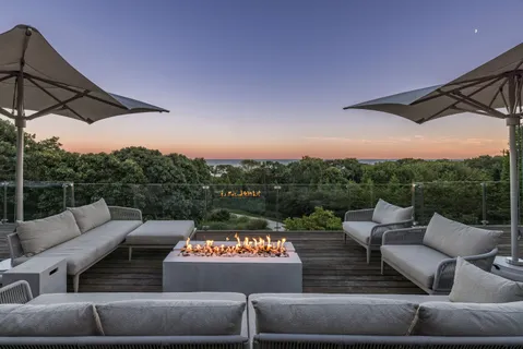 a roof deck with couches and potted plants