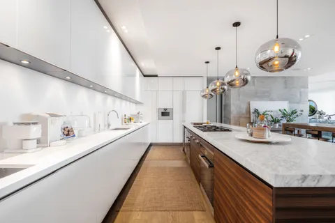 a large kitchen with lots of counter space and wooden floor