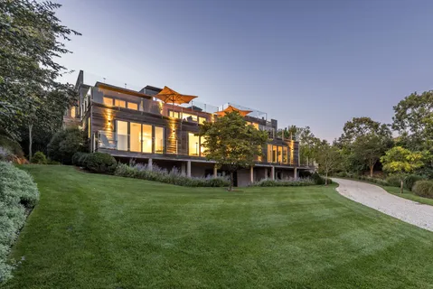 a view of a house with a big yard and potted plants in front of house
