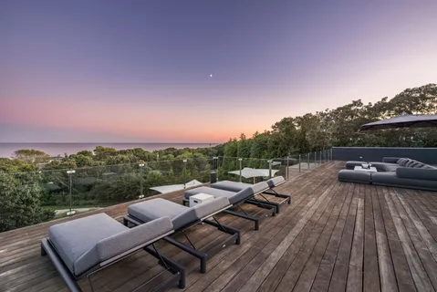 a view of a roof deck with couches and sky view