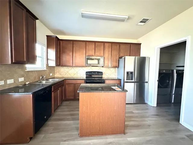 a kitchen with a refrigerator a stove top oven a sink and dishwasher
