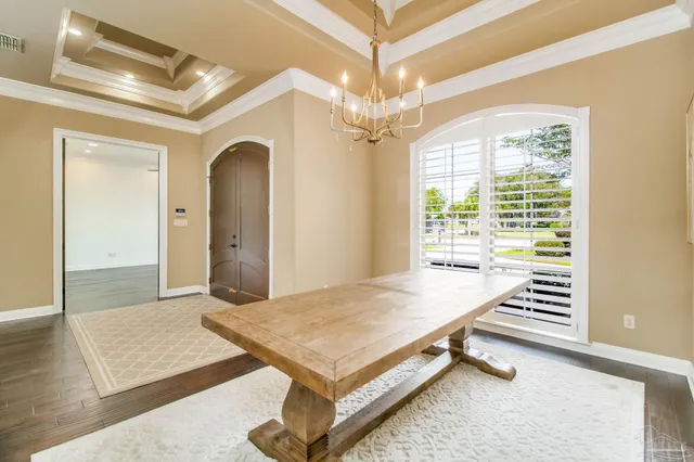 a living room with a table a chandelier and couches