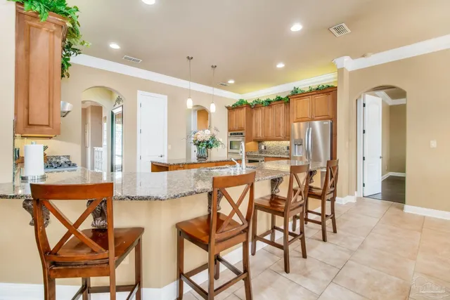 a kitchen with kitchen island granite countertop a sink cabinets and wooden floor