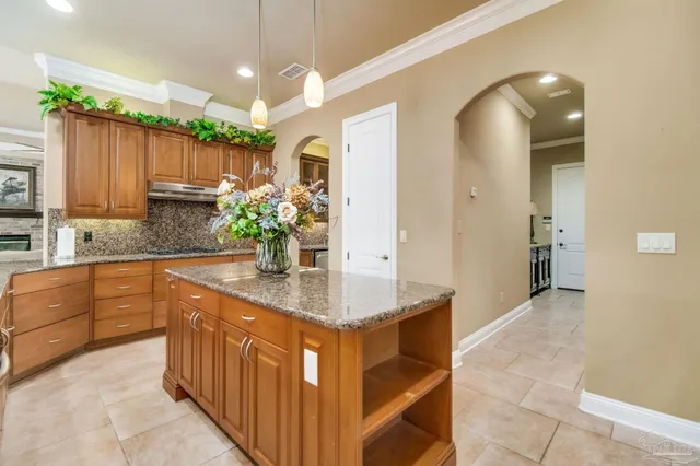 a kitchen with kitchen island granite countertop a sink and a large window