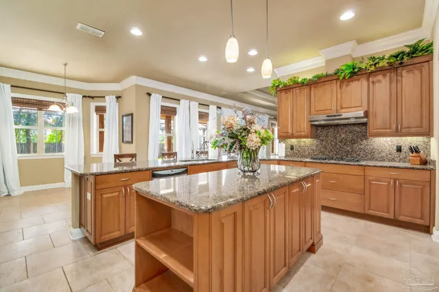 a kitchen with kitchen island granite countertop a sink counter space appliances and cabinets