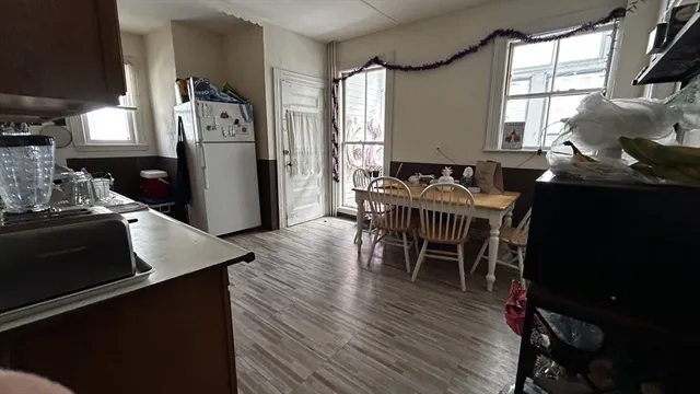 a kitchen with stainless steel appliances granite countertop a table chairs and a refrigerator