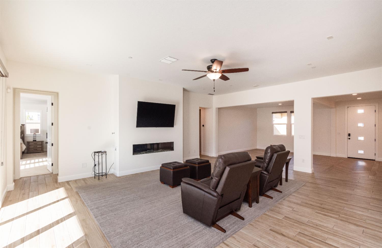 124 Basile Court Lincoln, CA 95648 - Photo 16 of 55 living room with light wood-type flooring, ceiling fan, and a glass covered fireplace