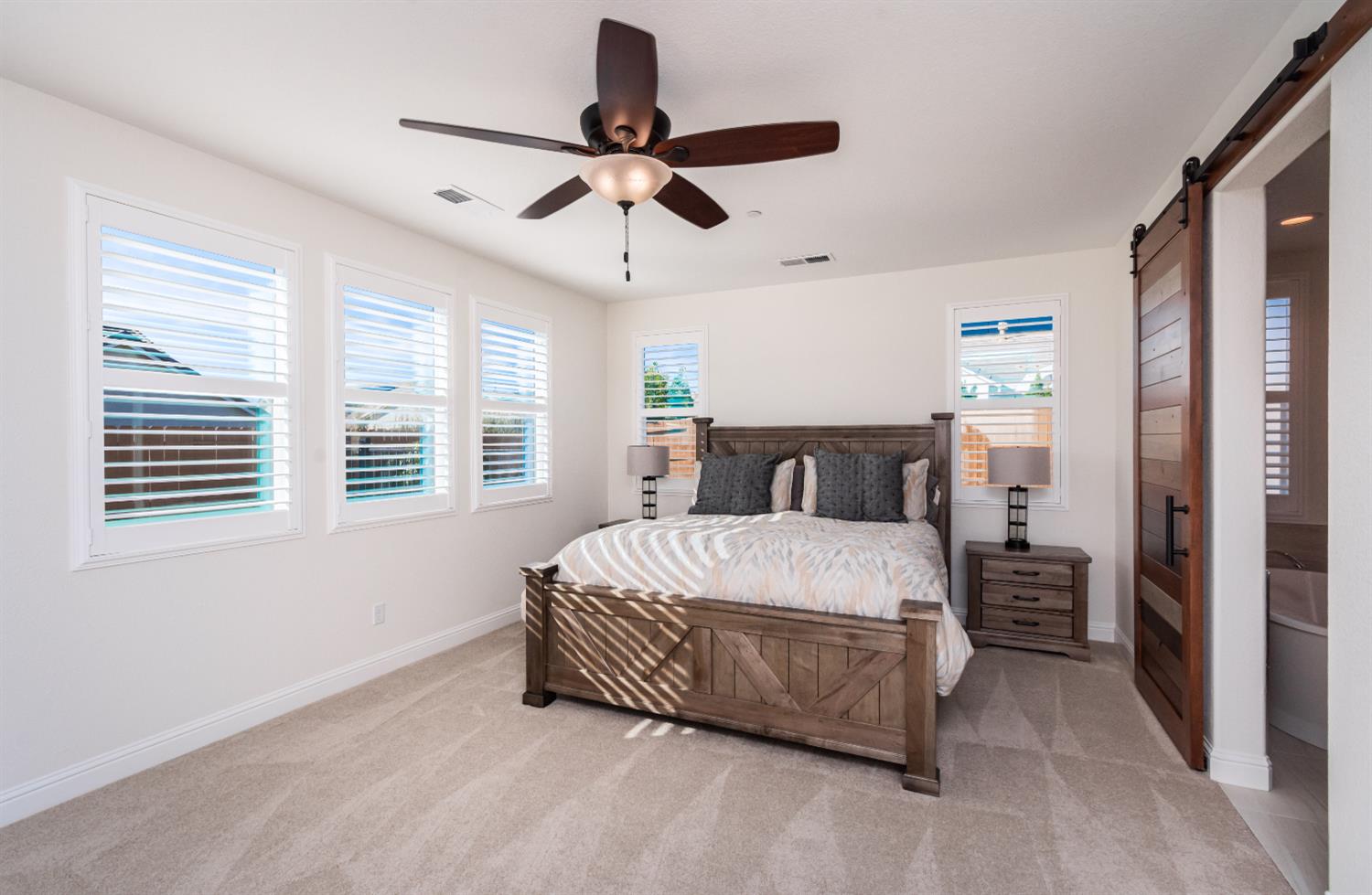 124 Basile Court Lincoln, CA 95648 - Photo 20 of 55 carpeted bedroom with a barn door and ceiling fan