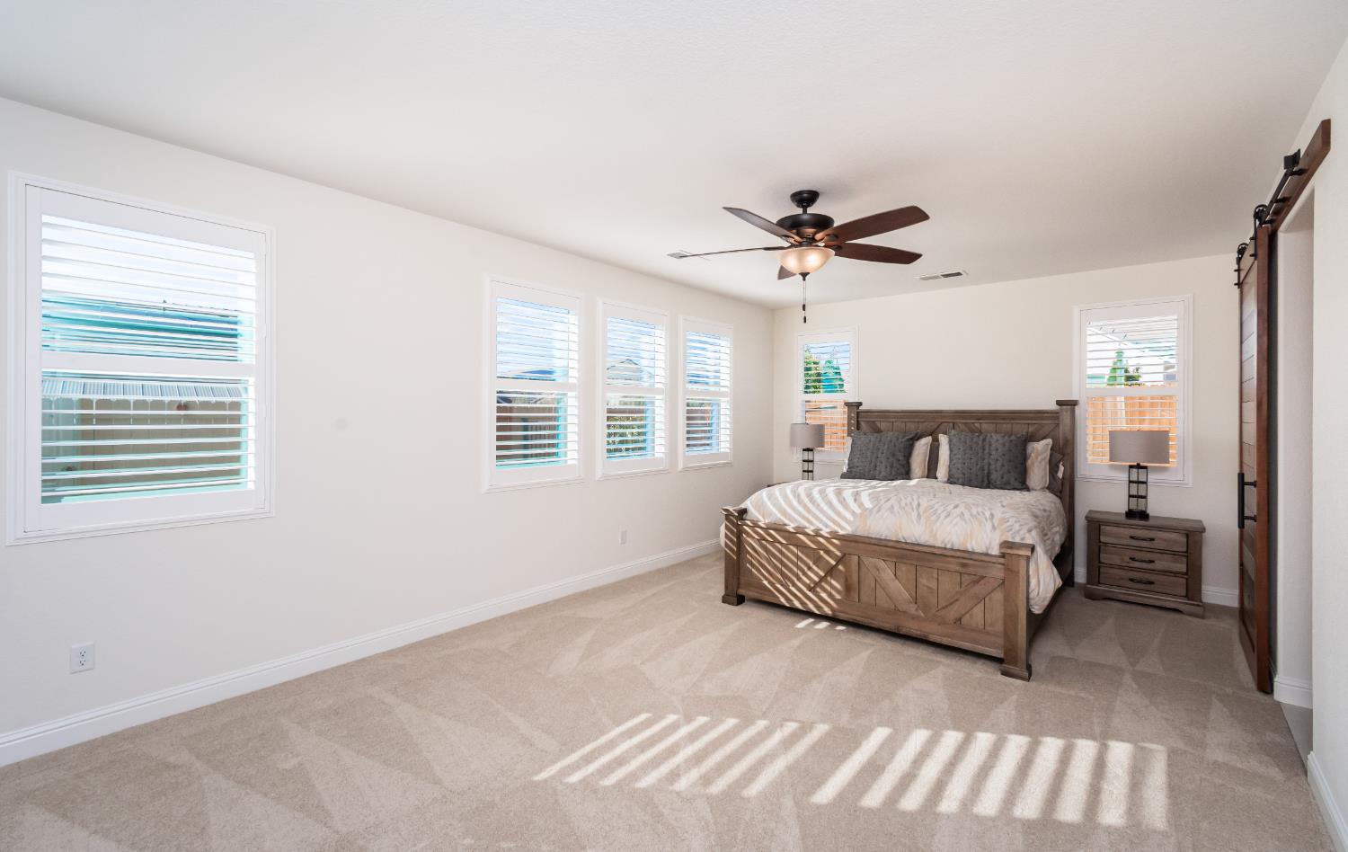 124 Basile Court Lincoln, CA 95648 - Photo 27 of 64 a spacious bedroom with a bed and a ceiling fan
