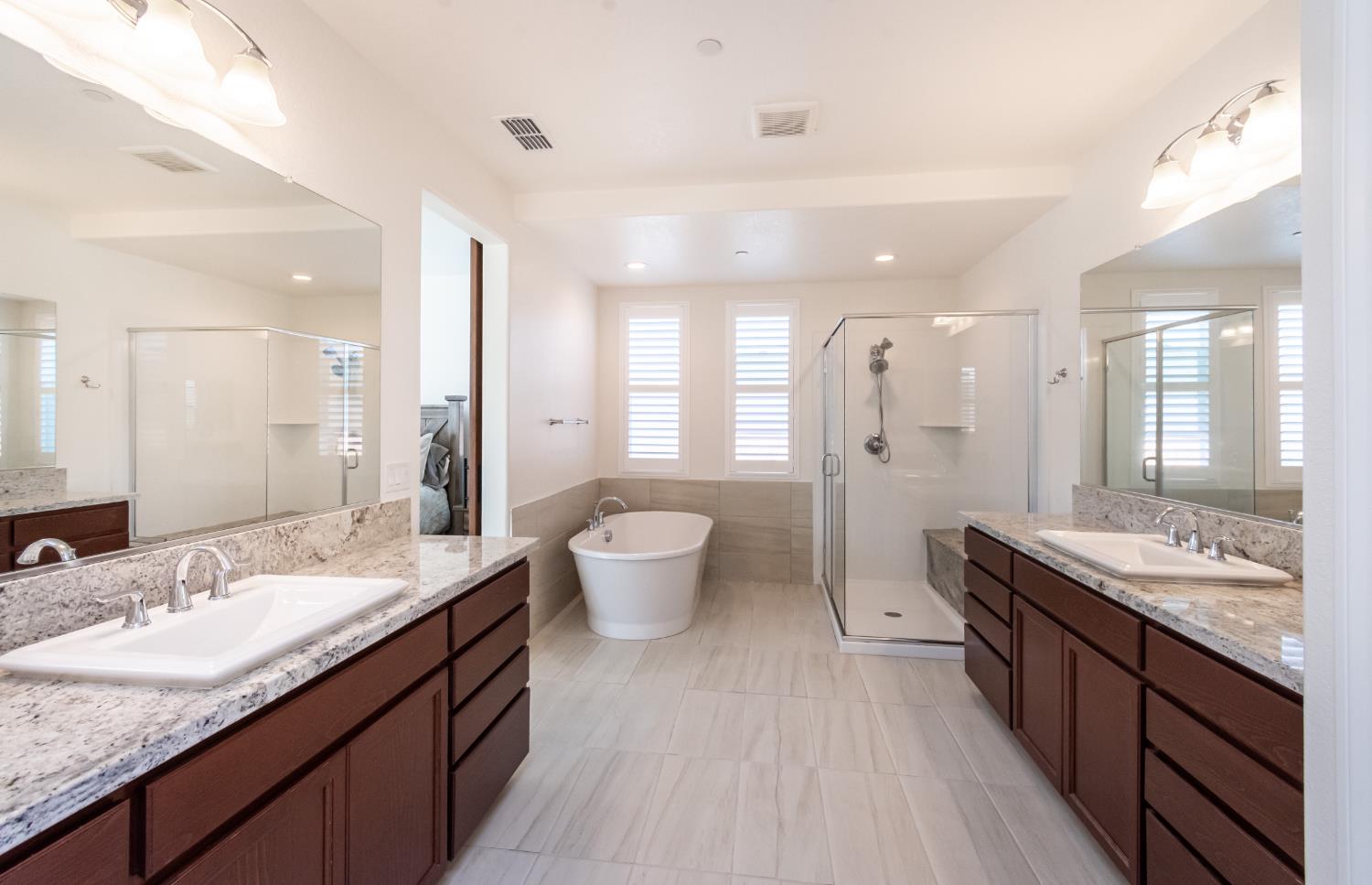 124 Basile Court Lincoln, CA 95648 - Photo 31 of 64 a spacious bathroom with a granite countertop double vanity sinks a mirror and a shower