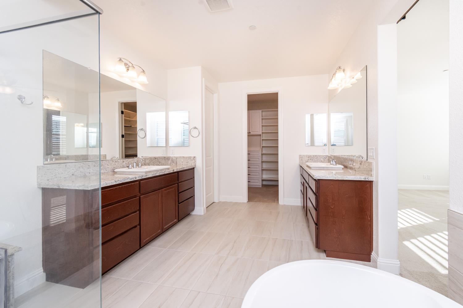 124 Basile Court Lincoln, CA 95648 - Photo 32 of 64 a spacious bathroom with a double vanity sink toilet mirror and bathtub