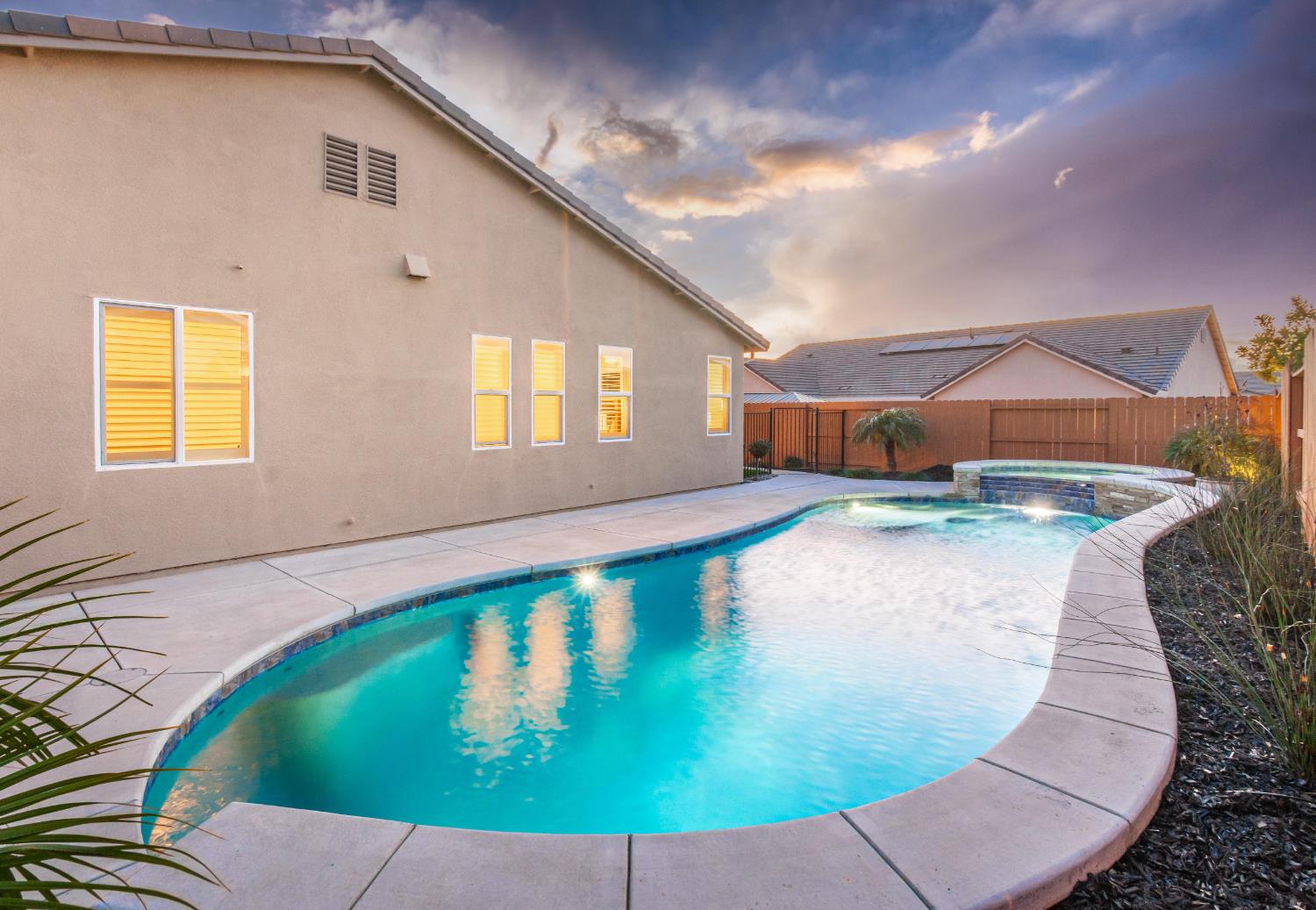 124 Basile Court Lincoln, CA 95648 - Photo 42 of 55 pool at dusk with a fenced backyard, a patio area, and a pool with connected hot tub