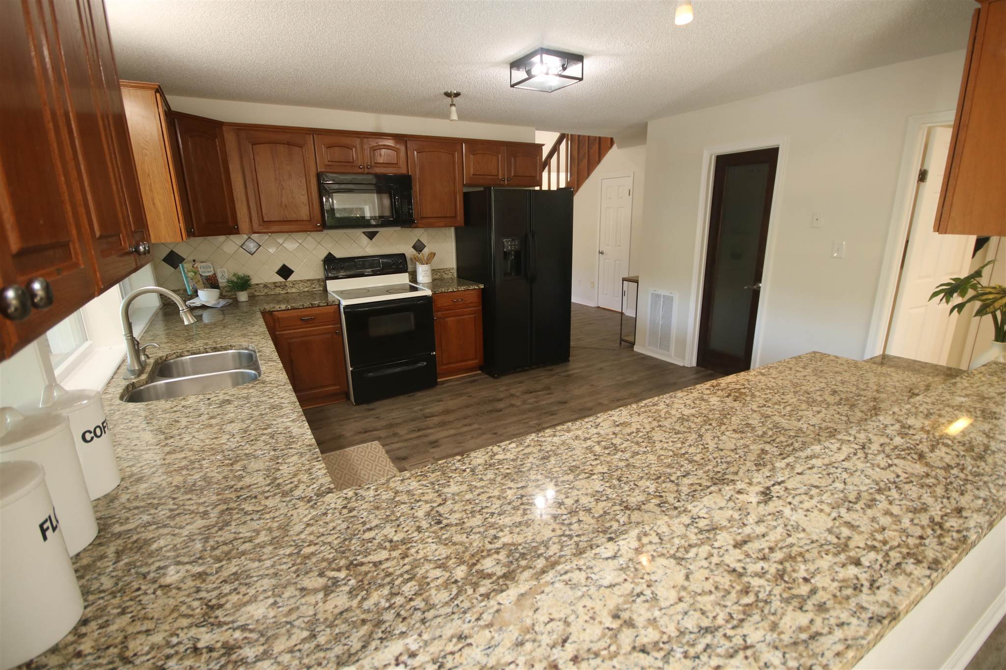 5425 Rowe Trail Pace, FL 32571 - Photo 29 of 50 a large kitchen with granite countertop a stove a sink dishwasher a refrigerator and a oven with wooden cabinets