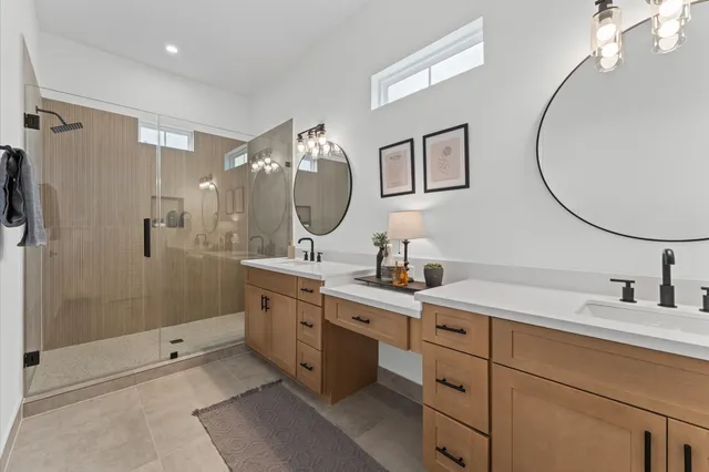 a bathroom with a double vanity sink mirror and shower