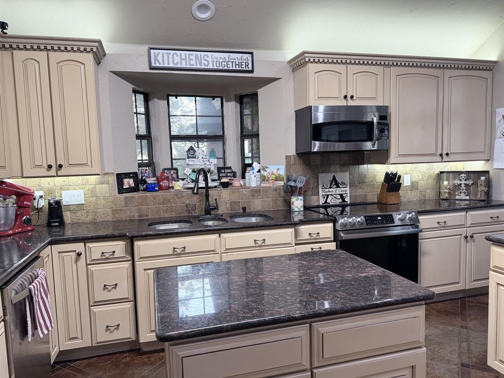 313 An County Road, Unit 2145 Palestine, TX 75801 - Photo 33 of 40 Kitchen featuring an island, light-toned cabinetry, dark countertops, built-in microwave, and a double basin sink