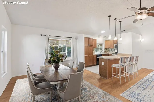 a dining room with furniture a chandelier and wooden floor
