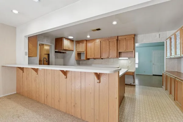 a kitchen with kitchen island a counter top space a sink and appliances