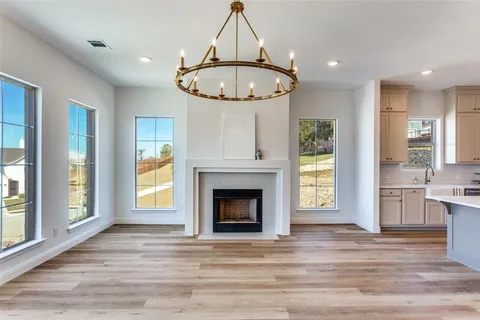 a view of an empty room with a fireplace and window