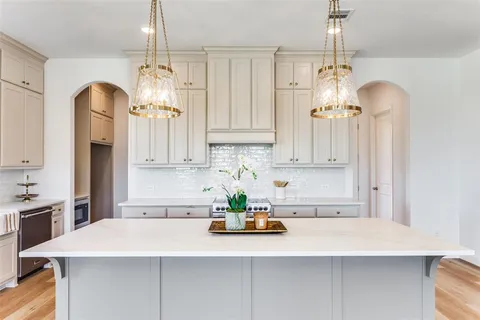 a kitchen with kitchen island granite countertop a sink a center island and cabinets