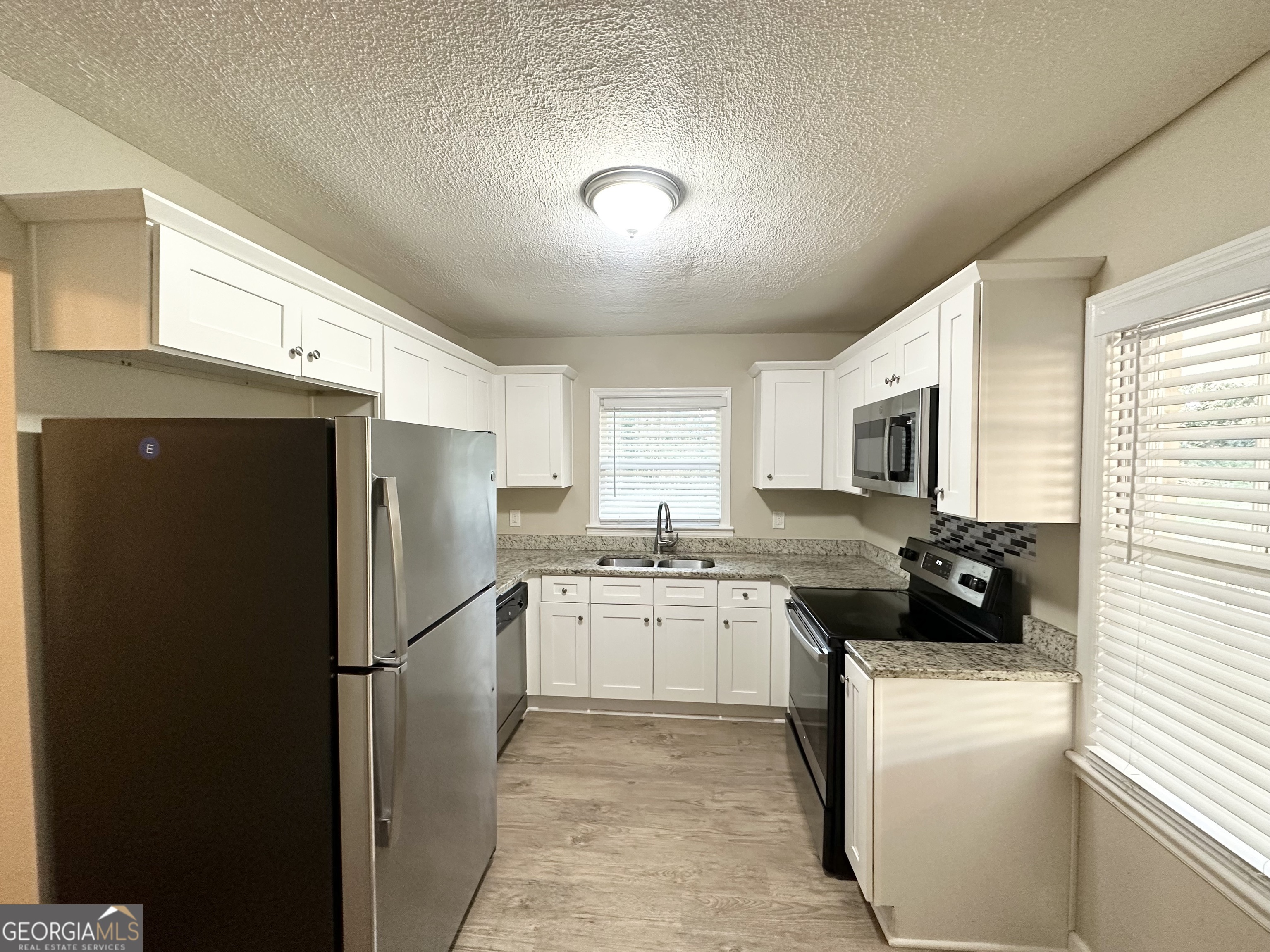 4267 Lamar Street Decatur, GA 30035 - Photo 3 of 14 a kitchen with a refrigerator and a stove top oven