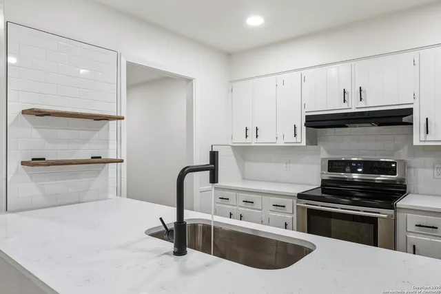 a kitchen with granite countertop a stove and a refrigerator