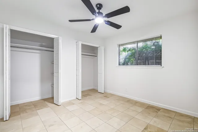 a view of an empty room with a ceiling fan
