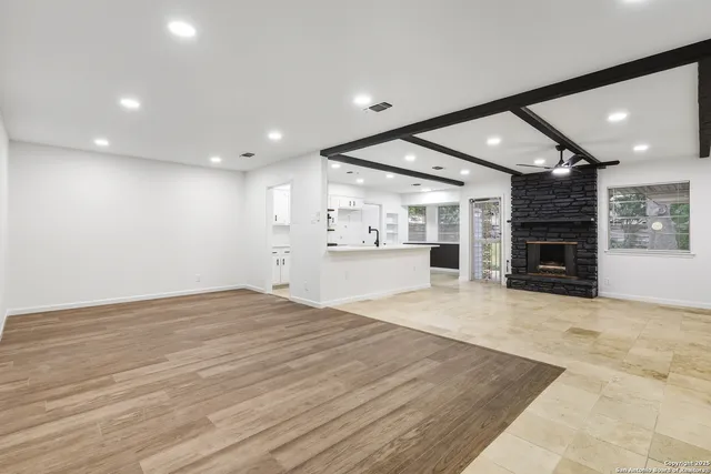 an empty room with wooden floor and fireplace