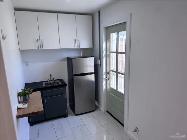 a kitchen with granite countertop white cabinets and stainless steel appliances