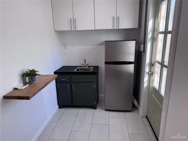 a kitchen with a refrigerator and cabinets
